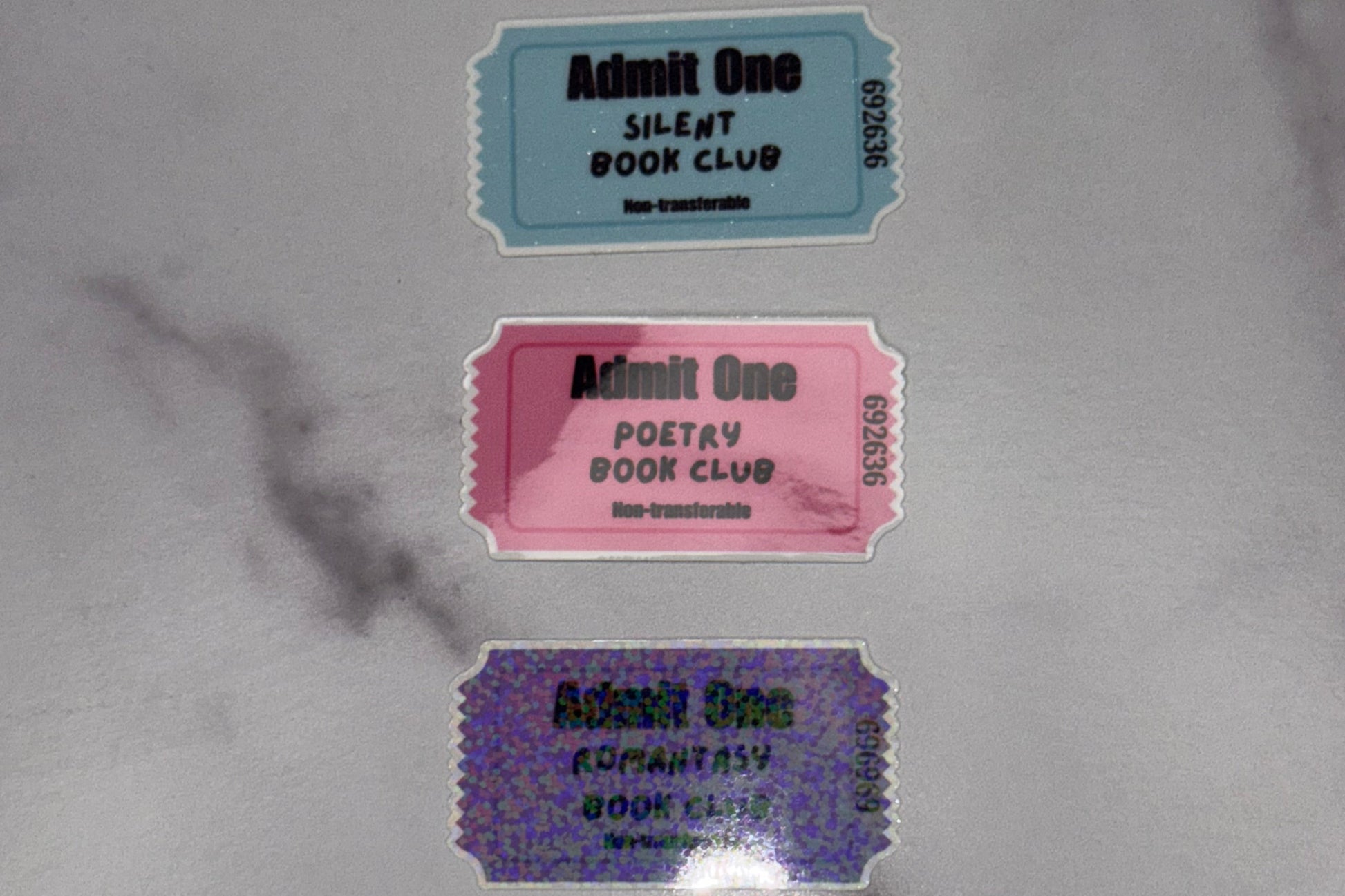 Three vintage-style admission tickets on a marble surface