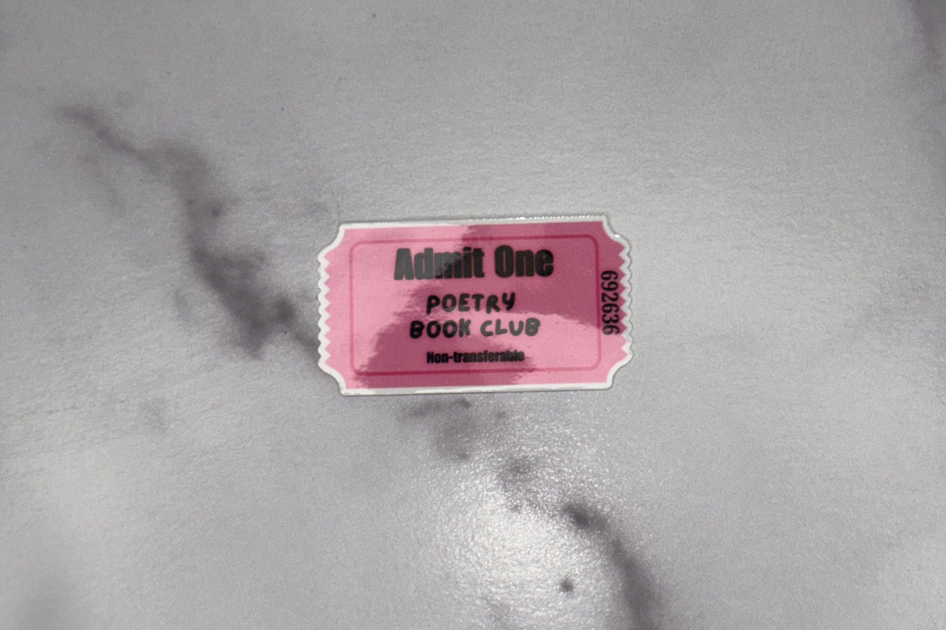 Pink ticket with text on a marble surface